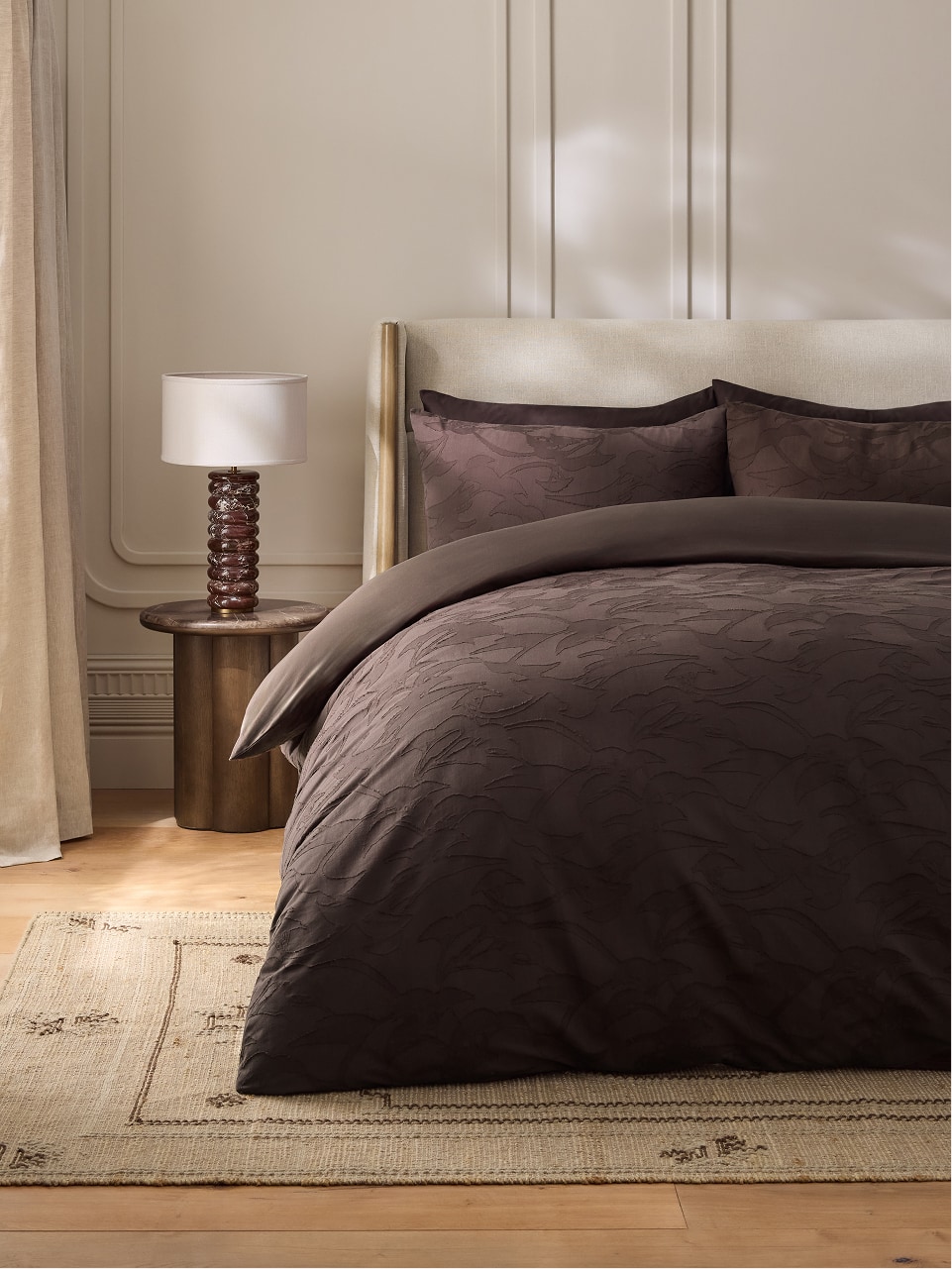 Bed dressed in chocolate brown jacquard bedding
