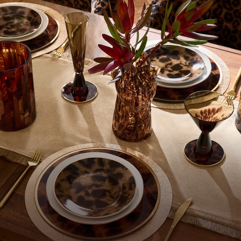 Leopard print plates and amber glassware on a dining table