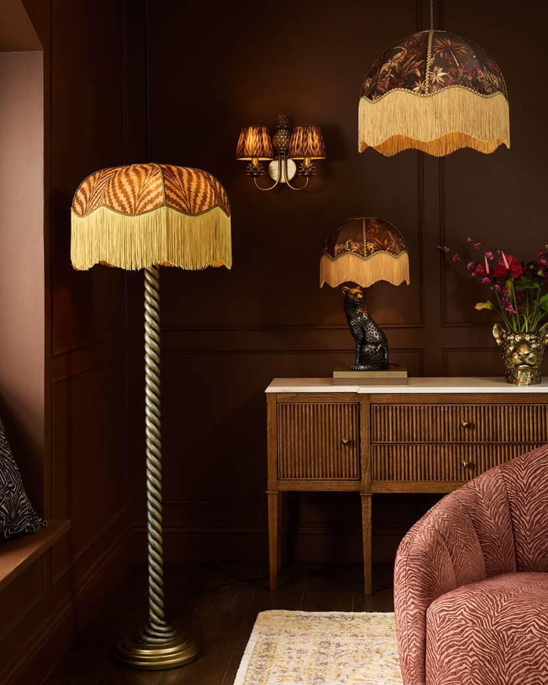 Room styled with a brass serpent floor lamp, black leopard table lamp and matching leopard ceiling shade