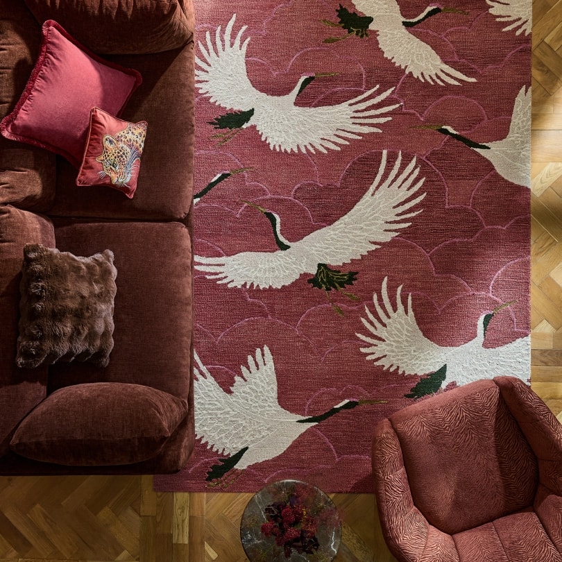 Velvet sofa with cushions on a crane print rug