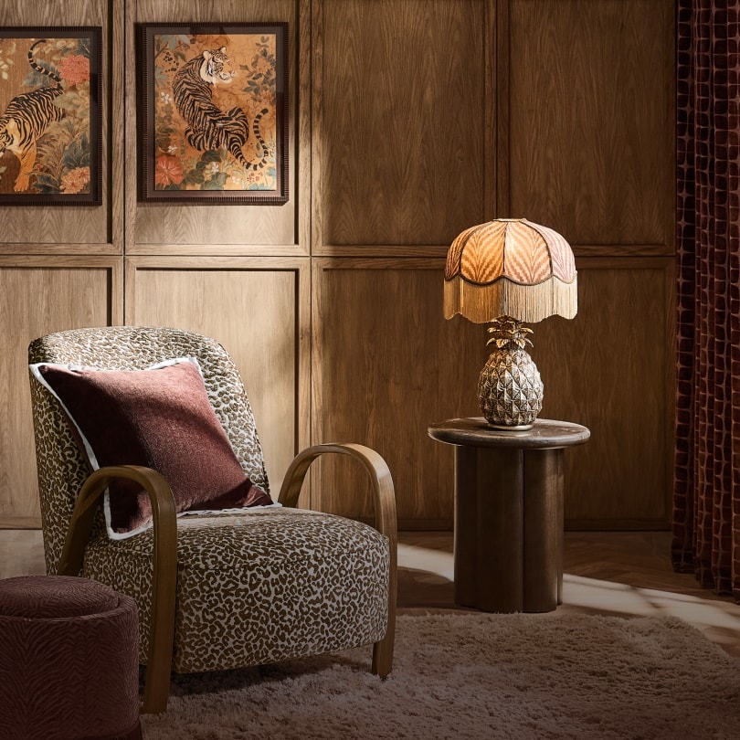 Leopard print armchair beside a fringed table lamp